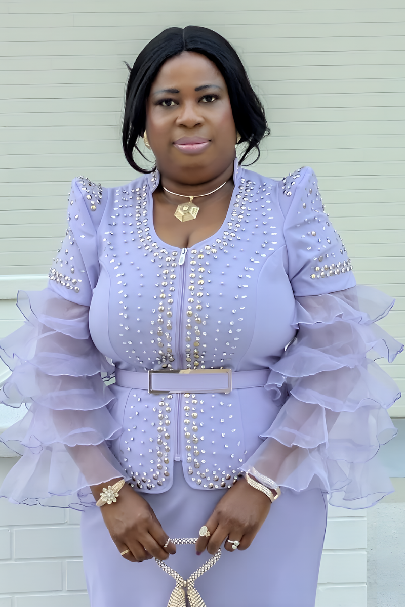 Woman wearing a light purple outfit with ruffled sleeves against a white background
